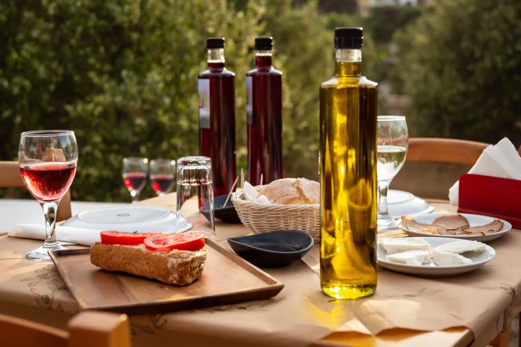Table of Mykonian delicacies, homemade wine and olive oil
